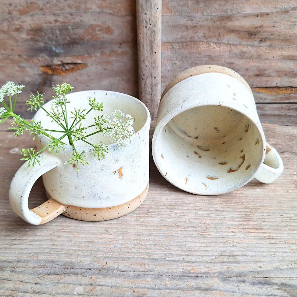 Skodelica iz kamenine v krem barvi.